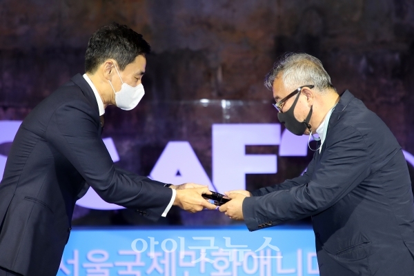 SICAF2021 임용섭 조직위원장이 백석예술대 영상학부 김재호 교수에게 공로상을 수여하고 있다.